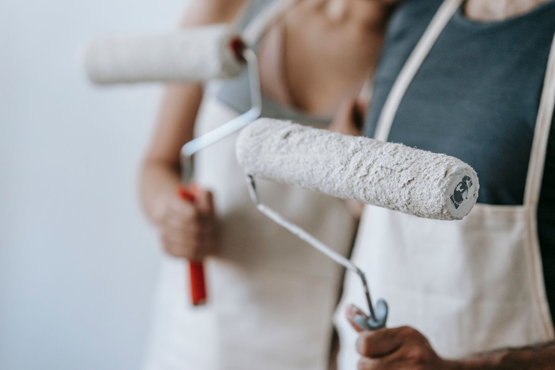 Close-up of a couple painting their new home with rollers, engaged in home improvement in Temecula, CA